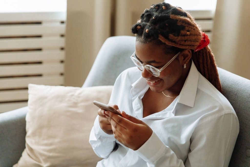 A woman smiling as she reads the weekly health e-letter on her phone
